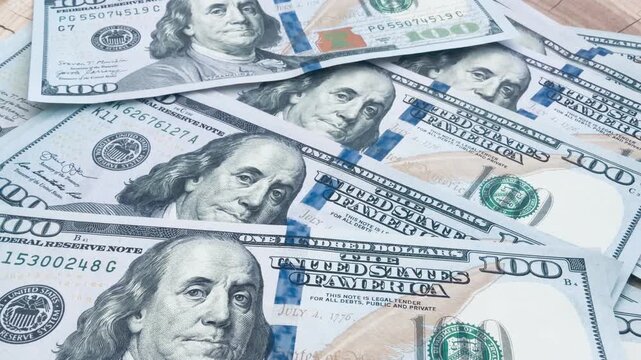 Luxury stack of US dollar bills on a prestigious solid oak table. Financial success, wealth and chic lifestyle concept. Cash money on expensive wood surface for premium business background.