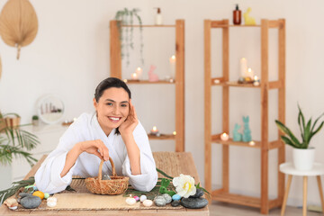 Obraz premium Young woman with Easter eggs lying in spa salon