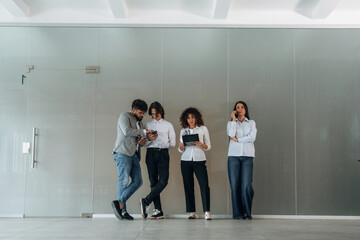 Fototapeta premium Front view of four office workers that are standing indoors and waiting