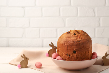 Bowl with delicious Easter cake and painted eggs on white wooden table
