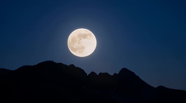 Full Moon Shining Brightly Above Silhouetted Mountain Ridges Under the Night Sky