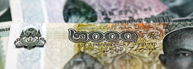Cambodian riel money bills pile on table. Cambodia banknotes of KHR currency close up. Concept of business, economy and banking in Cambodia © mehaniq41