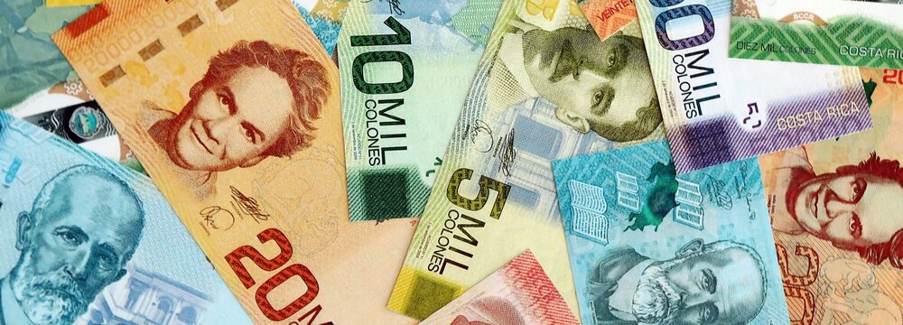 Costa Rican old and new colon money bills pile on table. Costa Rica banknotes of CRC currency close up. Concept of business, economy and banking in Costa Rica
