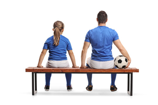 Rear view shot of a girl and football player sitting on a bench