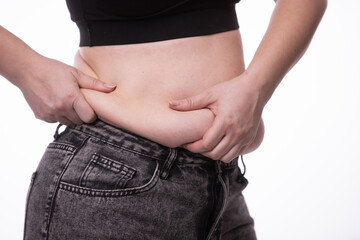 Naklejka premium Fat woman trying to zip up her jeans pants. Women's health. Women body fat belly. Obese woman hand holding excessive belly fat. Diet lifestyle concept, healthy stomach muscle.