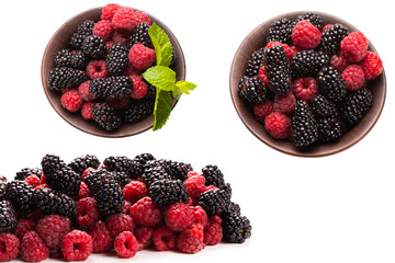 Raspberry, blackberry and mint leaf in ceramic brown bowl isolated on white © Nikolay