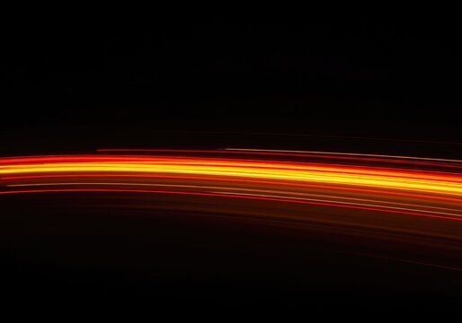 Streaks of vibrant, glowing residual light captured in a slow-shutter abstract composition, creating smooth, dynamic trails of color and energy, streak, texture, dark
