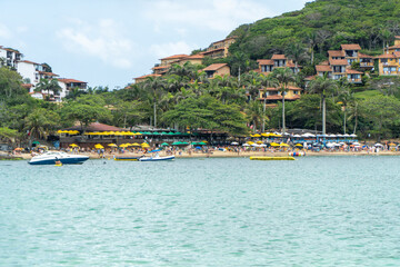 Fototapeta premium View of João Fernandes beach from João Fernandinho with boats and tropical houses over greenery in Búzios Rio de Janeiro Brazil – coastal tourism and seaside lifestyle