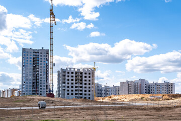 Urban residential high-rise buildings under construction with tower cranes and construction materials on site © Eugeniusz