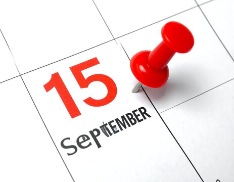Close up of "15 September" date on a calendar, marked with a red pushpin, denoting a scheduled event