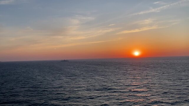 Sonnenuntergang &uuml;ber dem Meer vom Schiff aus, ruhige Wellen und warme Farben, romantische Stimmung und Fernweh, Blick von Kreuzfahrt oder Frachter mit Copyspace