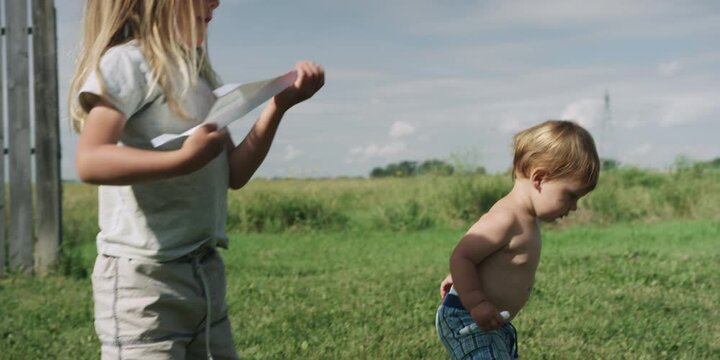 Two children playing together in a grassy field