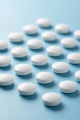 Rows of white medicinal pills arranged neatly on a blue background representing healthcare and pharmacy.