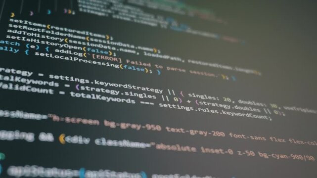 A computer monitor displays scrolling lines of complex programming code in a dark interface. Concept of modern vibe coding, artificial intelligence, and software application creation.