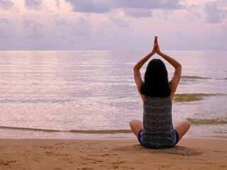 Woman practicing yoga on tranquil beach