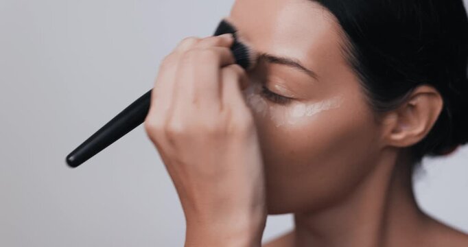 Close-Up Woman Applying Foundation Makeup with Brush in Studio