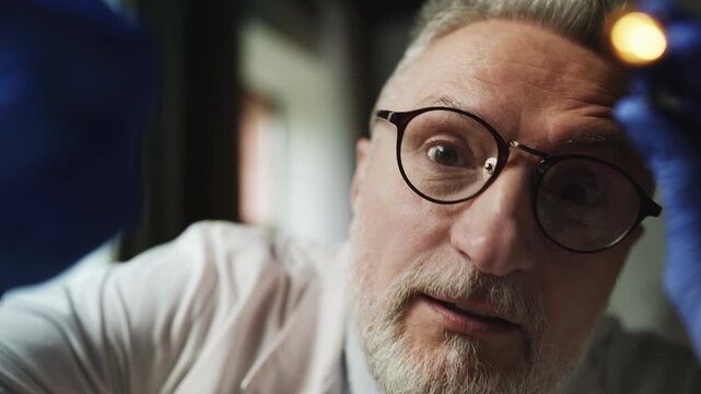 POV of male otolaryngologist checking patient's throat, lymph nodes and tonsils