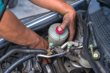 Obraz premium Close up car mechanic repairing engine and replacing spare parts in auto repair shop