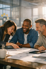 Fototapeta premium Cheerful colleagues discussing architectural plans modern office