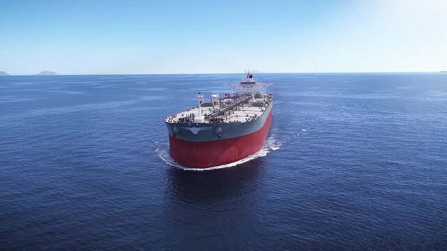 Panoramic aerial view of a crude oil super tanker ship traveling with speed over the open ocean