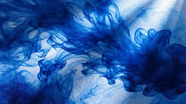 Blue ink swirls and spreads, creating an abstract fluid art background.