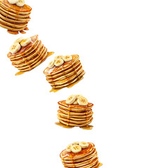 Stacks of banana topped pancakes drizzled with syrup from above plates, isolated on white background, concept of breakfast