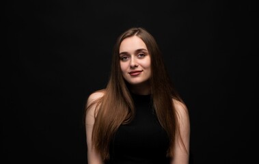 Naklejka premium Young woman confidently posing with long brown hair, smiling portrait featuring beauty and freshness on black background