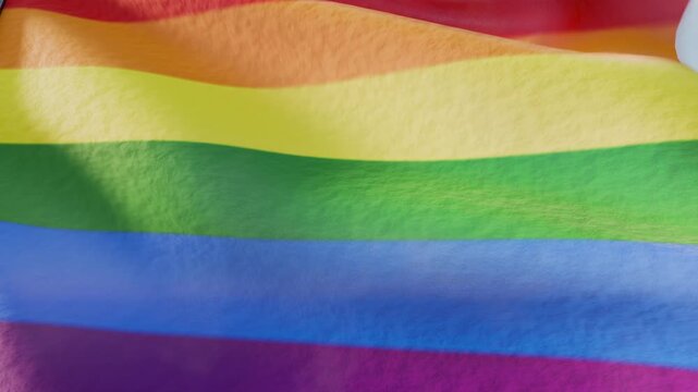 Pride month rainbow colored flag waving in the sky