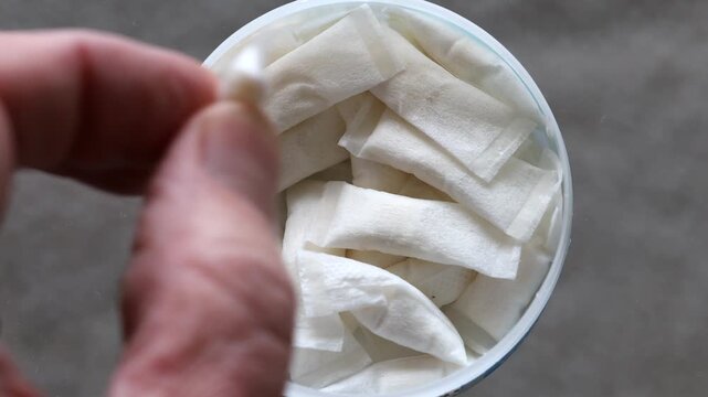 Stockholm, Sweden A man reaches for pouch smokeless tobacco in a plastic tin. 