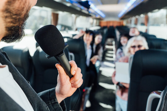 Group listening to a speaker on a bus during a trip to a city