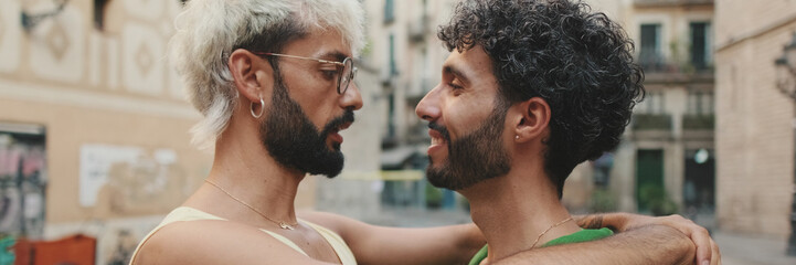 Close up, homosexual couple stands hugging on street of old city. Panoramic © Andrii Nekrasov