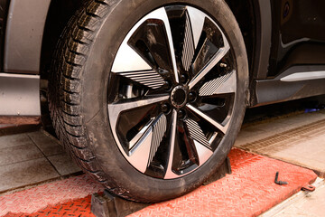 Wheel alignment and alignment on the car service platform. Car tire being repaired while on service...