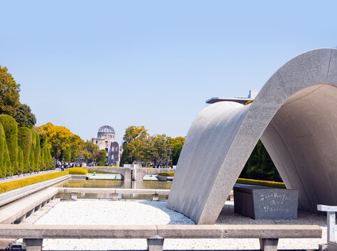 Cenotaph at Hiroshima peace park Atomic bomb dome in the background - Hiroshima, Japan