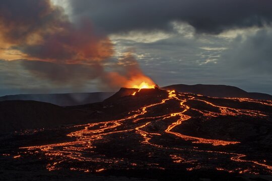 Lava spurting out of crater and reddish illuminated smoke cloud, lava flows, erupting volcano, Fagradalsfjall table volcano, Kr&yacute;suv&iacute;k volcano system, Reykjanes Peninsula, Iceland