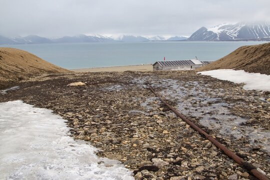Former mining station Calypsobyen, old pipeline with wooden barrack, view of Bellsund, Spitsbergen Island, Norway