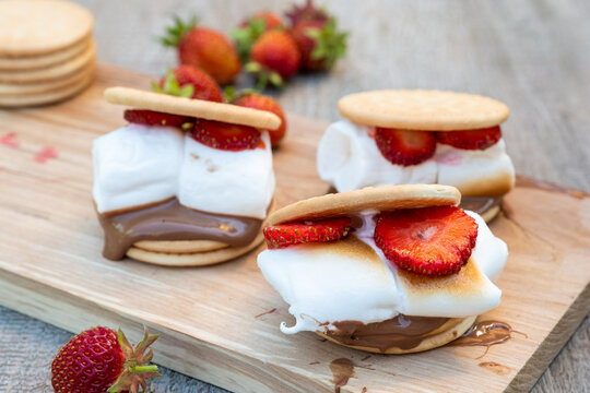 Making S'mores With Strawberries on a Wooden Board During a Warm Sunny Day