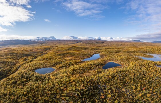 Autumn fell landscape and lakes with snow-covered mountains, Abisko, Lapland, Sweden
