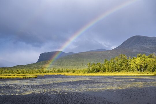 Rainbow in thunderstorm mood, Visttasjohka river delta, Nikkaluokta, Lapland, Sweden