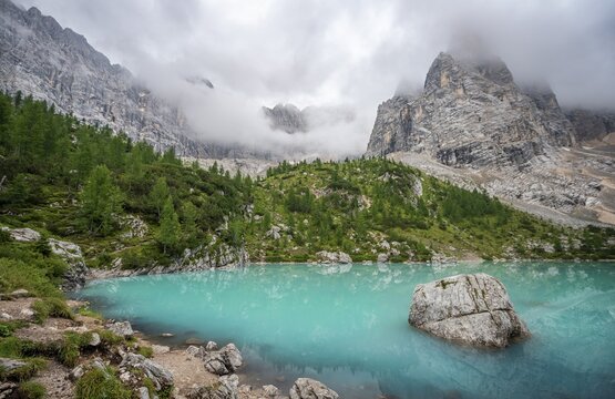 Turquoise green mountain lake, Sorapis lake, Lago di Sorapis with reflection, cloudy mountain peak Dito di Dio, Dolomites, Belluno, Italy