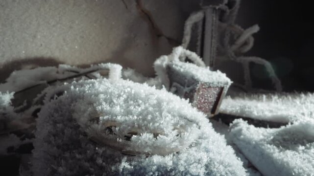 Old survival gear encased in icy frost. Scene of ancient equipment covered in metallic frost and ice. Nostalgic depiction of vintage survival tools frozen and embedded in icy frost