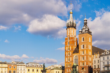 Fototapeta premium St. Mary's Basilica stands tall in Krakow's main square under a clear blue sky on a sunny day