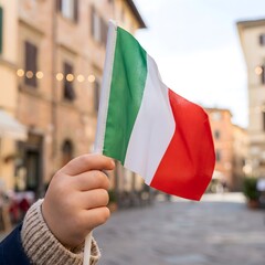 Child Hand Raising Italian Flag with Beautiful Blurred Background