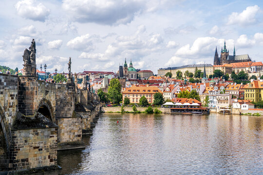 Panoramic view of Prague historic Mala Strana district, Prague Castle, the Vltava River and Charles Bridge in summer under a blue sky with white clouds, Prague, Czech Republic 