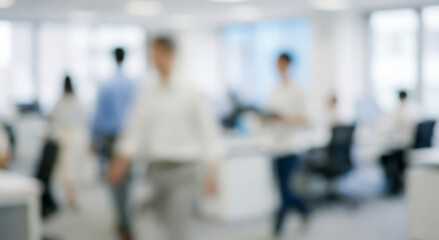Fototapeta premium A busy office environment with blurred figures of employees engaged in various tasks. The space is modern and bright with numerous workstations.
