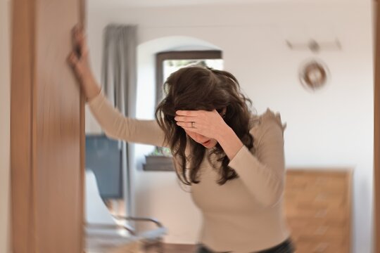 Blured photo of a woman suffering from vertigo or dizziness or other health problem of brain or inner ear.