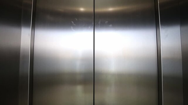 Elevator is arriving and doors open automatically, nobody. Black background