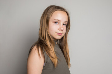Fototapeta premium Smart child girl with brown hair looking at camera, portrait. Young girl 10 years old