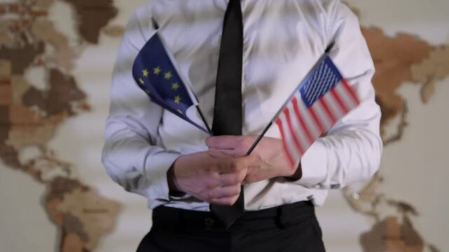 Holding European and American flags in front of a world map in a formal setting