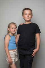 Little sibling portrait, young boy and girl standing together