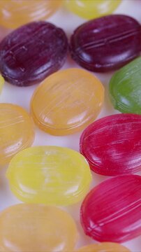 Colorful candy closeup. Bright candies with shiny shells. Multicolored sweets sparkling under bright light. Vivid confectionery with translucent shells and sugar crystals gleam